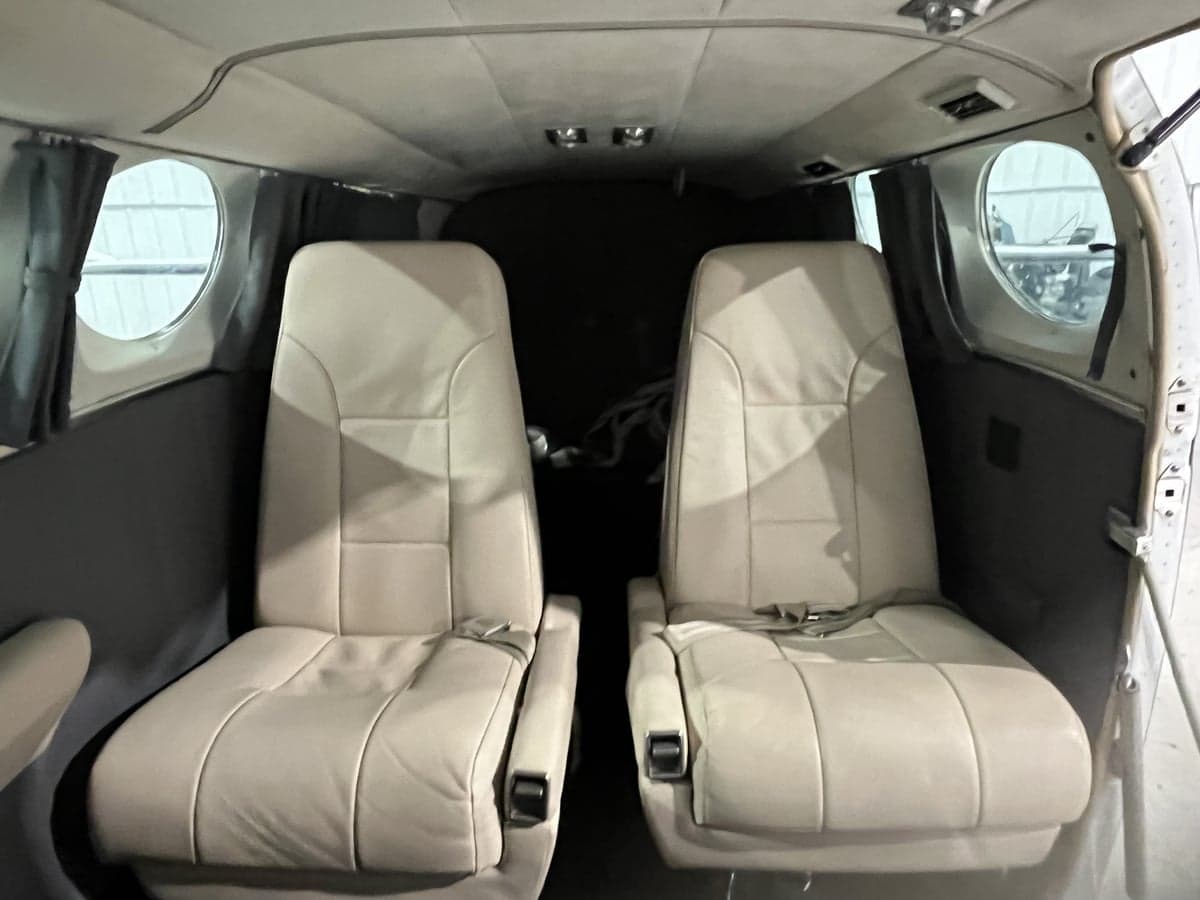 The aircraft's interior features cream-colored leather seats.