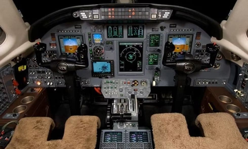 The interior of a private jet features leather seats and wood trim.