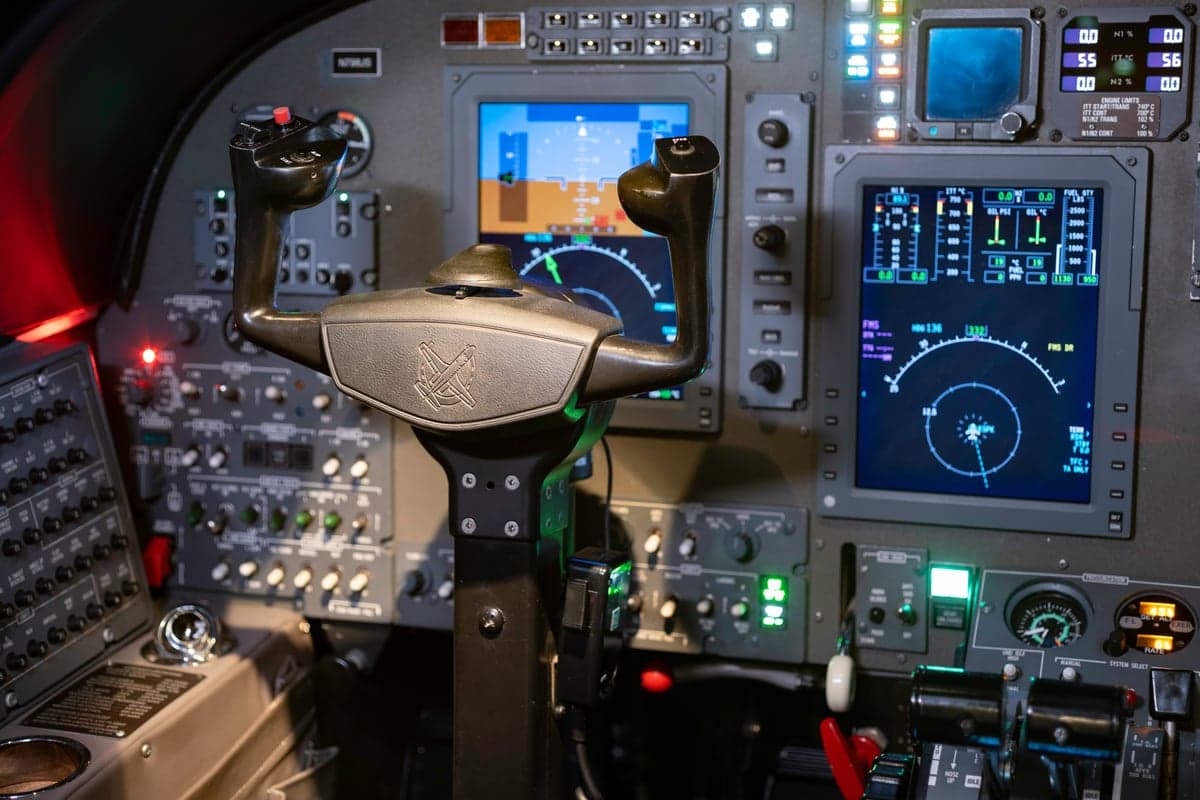 A close-up view of an aircraft's cockpit, featuring the control yoke and illuminated digital displays.