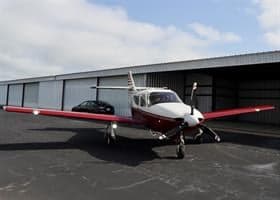 Front view of the N768F aircraft parked in front of a hangar.