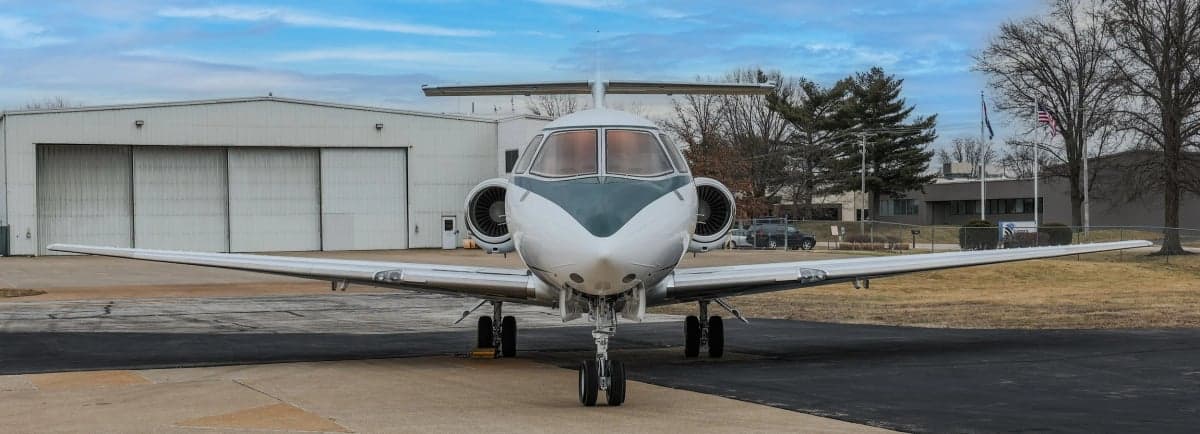 Front view of a Hawker 800XP with a white and gray paint scheme on the tarmac.