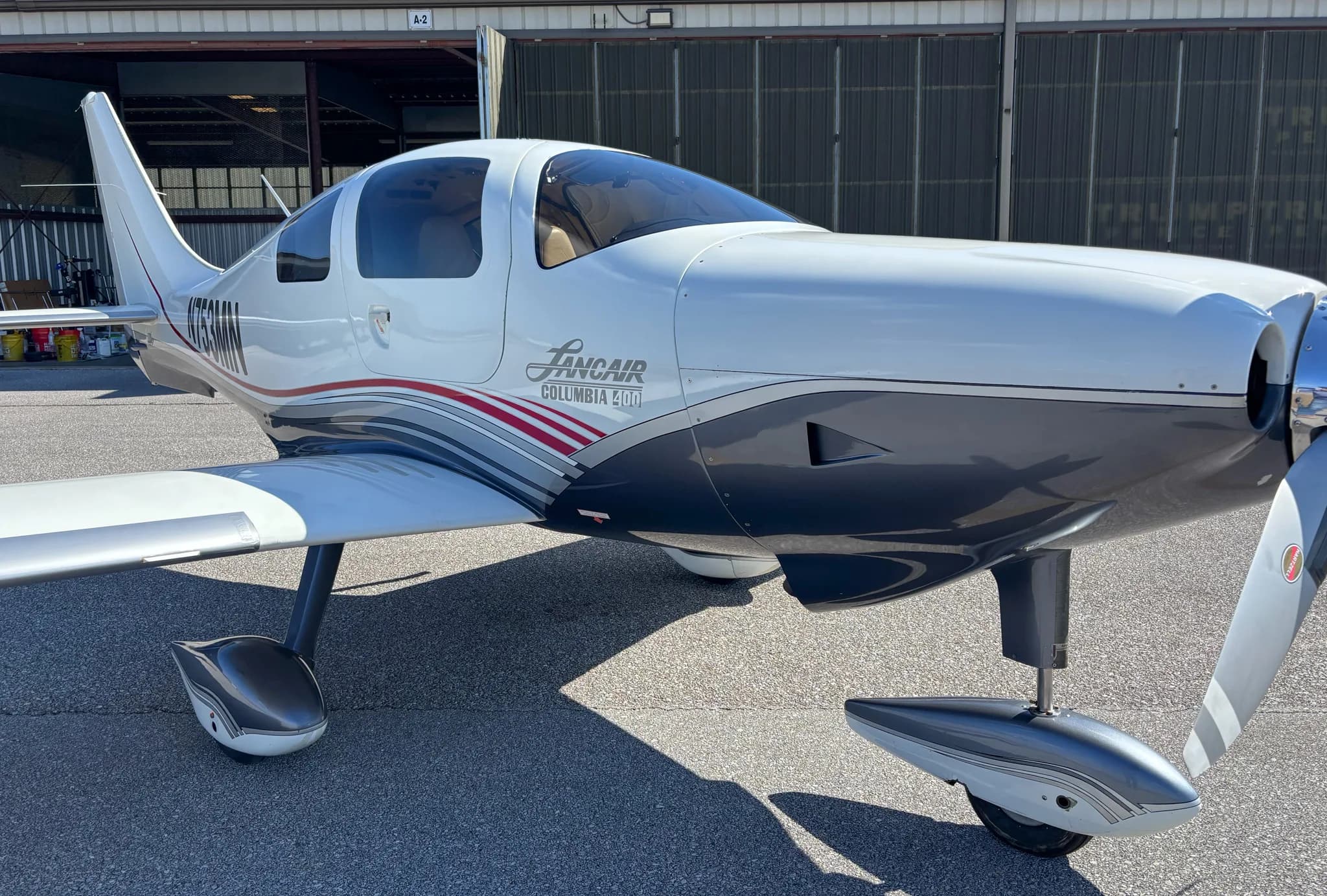 Close-up front-quarter view of the Lancair Columbia 400 N753MN showing its propeller and landing gear.
