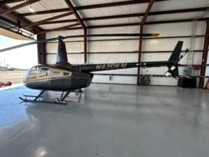 The Robinson R66 helicopter, registration N430KM, is parked inside a hangar.