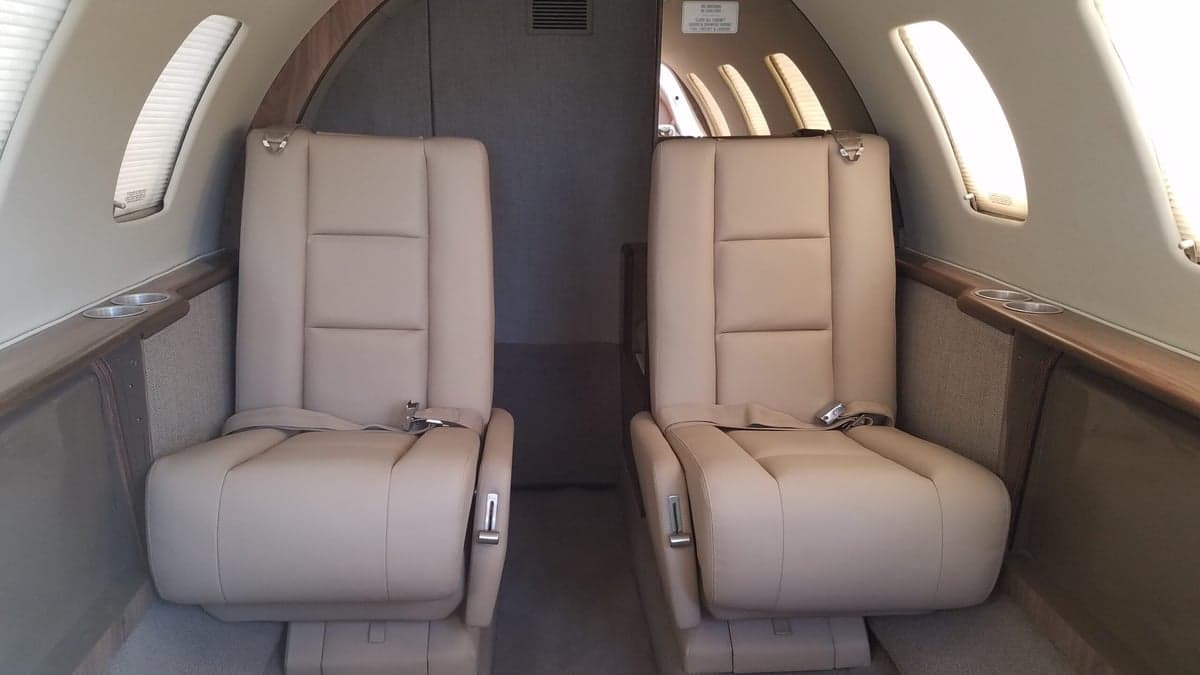 View of the aircraft's interior with two beige leather seats.