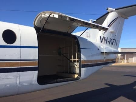 The open airstair door of a King Air aircraft shows the entry steps.