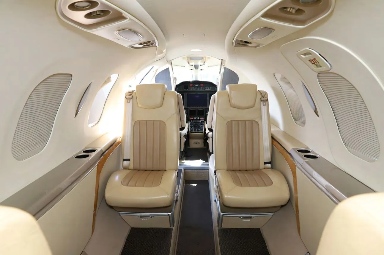 The interior cabin of a HondaJet Elite S, showing two tan leather seats facing forward towards the cockpit.