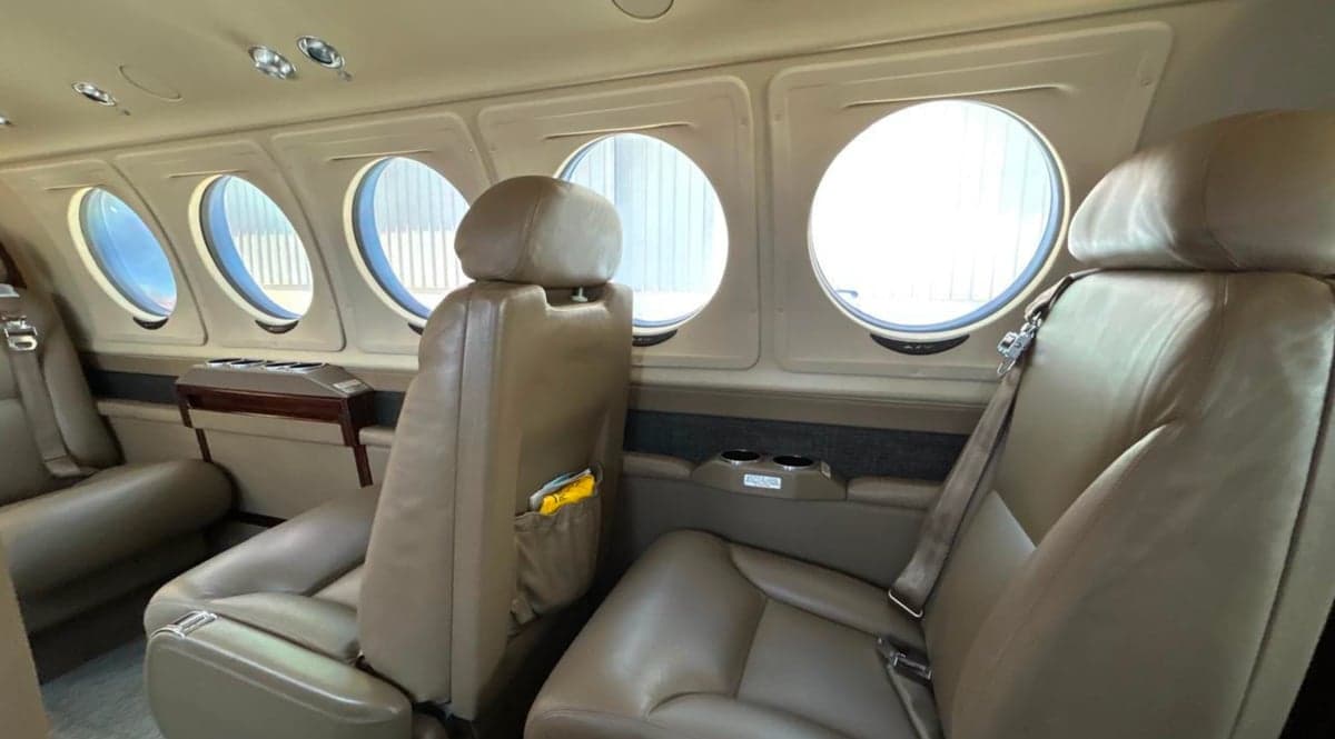 Interior of a King Air 250 with leather seats and round windows.
