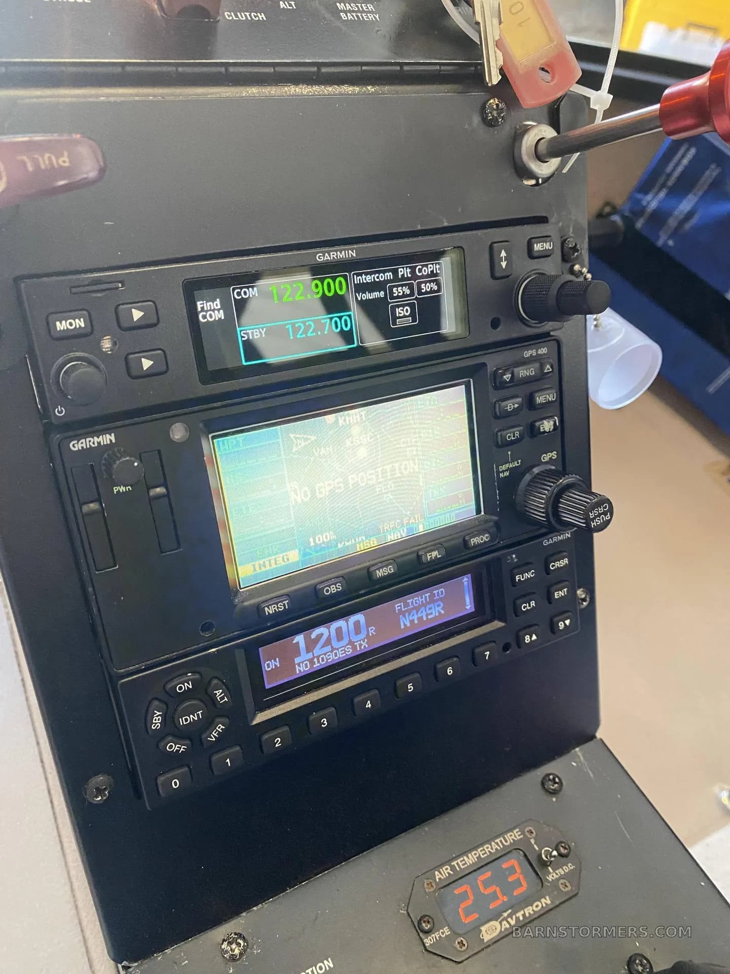 A close-up view of the Garmin avionics stack in a helicopter cockpit, displaying communication and navigation information.