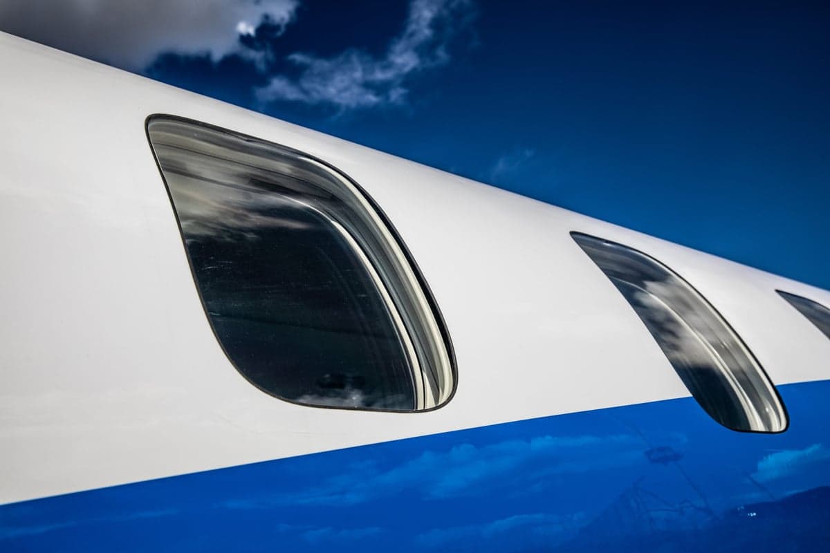 Close-up of the aircraft windows with a blue and white paint scheme.