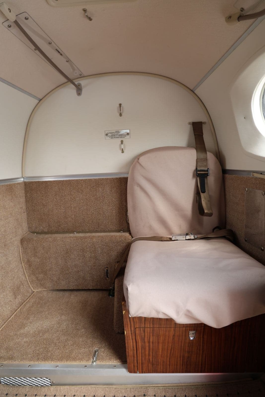 Interior view of an aircraft showing a single seat with a seatbelt.