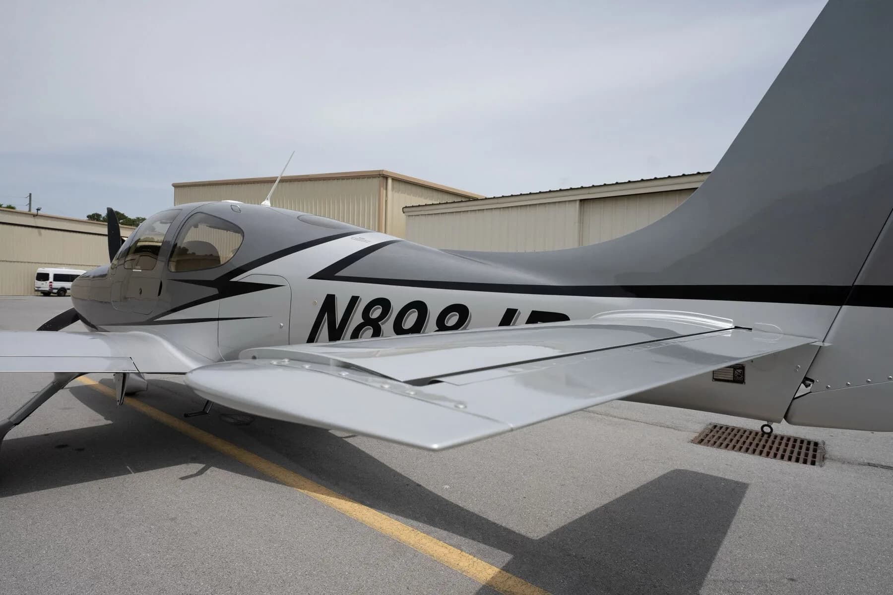 Close-up view of the silver Cirrus SR22's tail and right wing with registration N898JP.