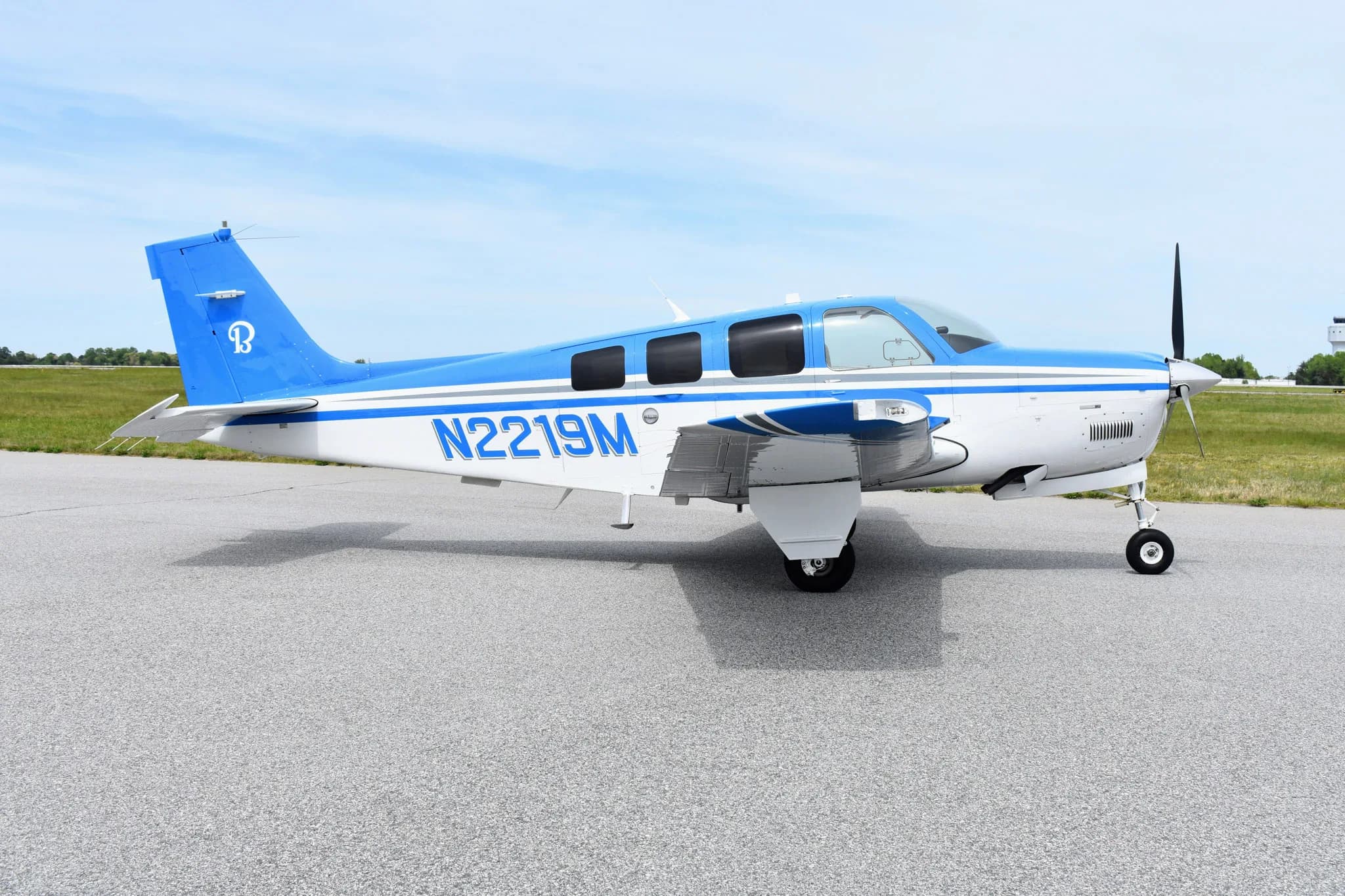 Beechcraft Bonanza with white and blue paint scheme on the tarmac.