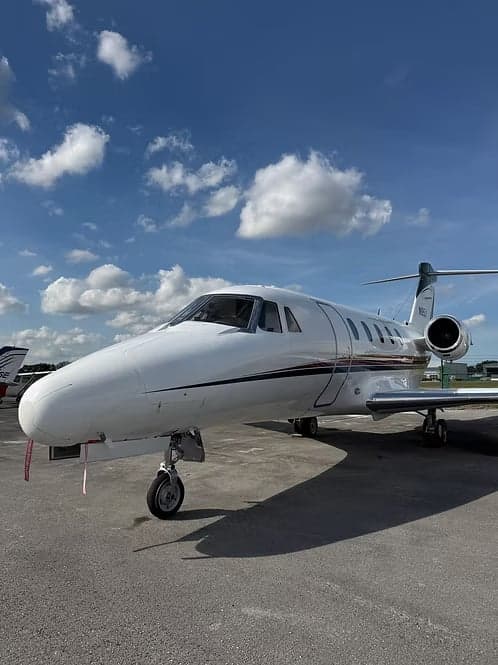 Cessna Citation CJ3+ on the tarmac with a blue sky and clouds.