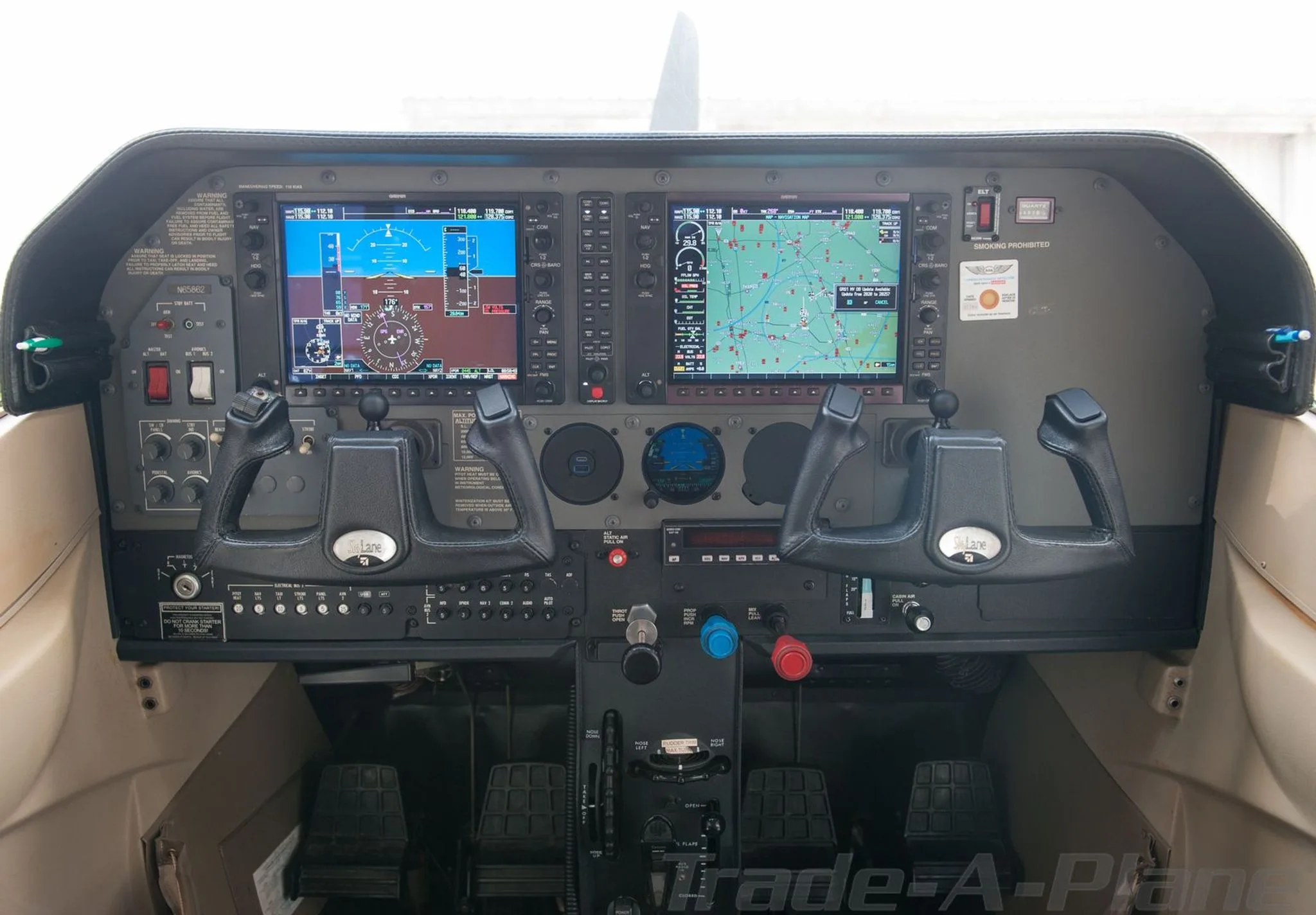 The cockpit of a Cessna Skylane, featuring a modern glass panel with two large displays and dual yokes.