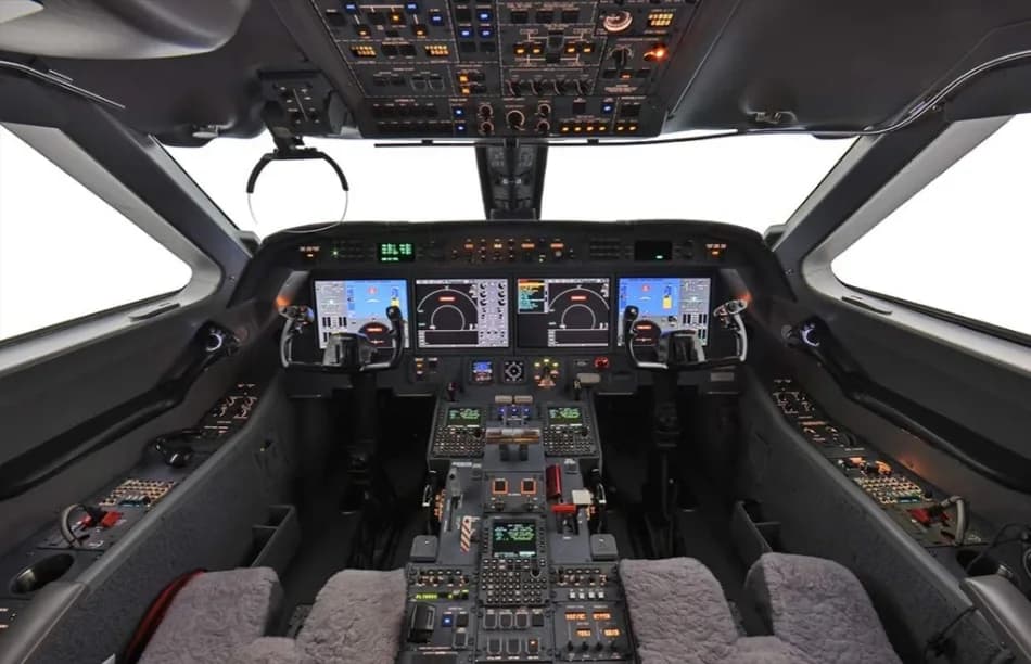 The modern cockpit of a business jet, featuring multiple digital displays and a complex control panel.