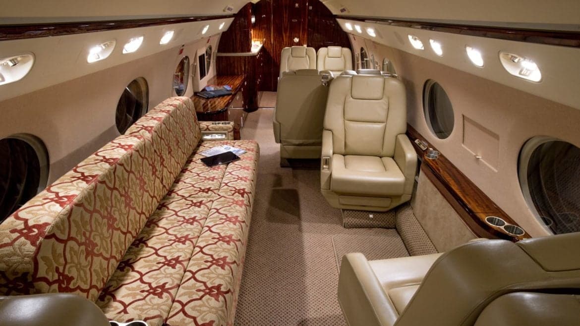 The interior of the aircraft features a patterned couch and leather seats.