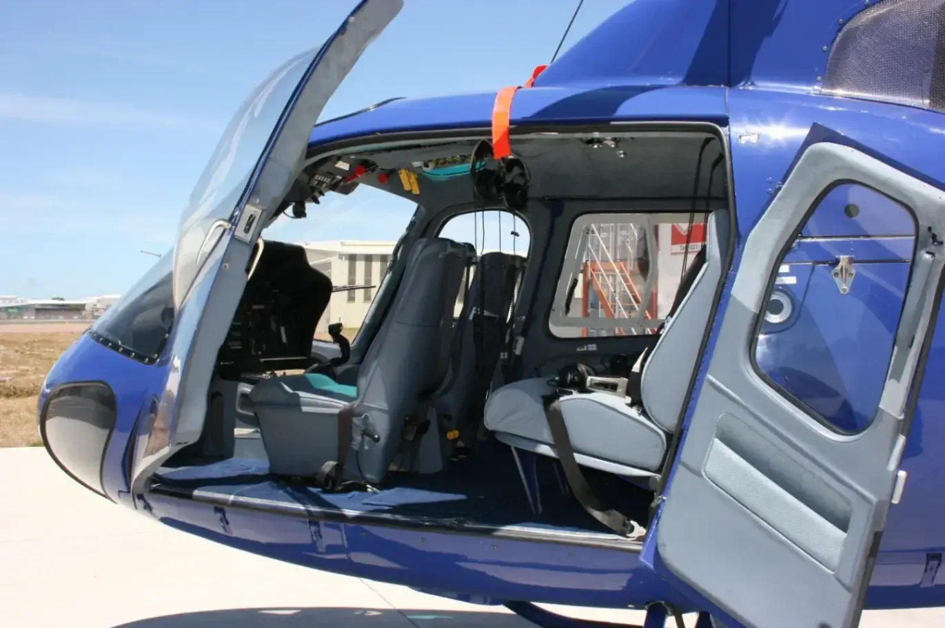 View of the helicopter's interior with seats and open doors.