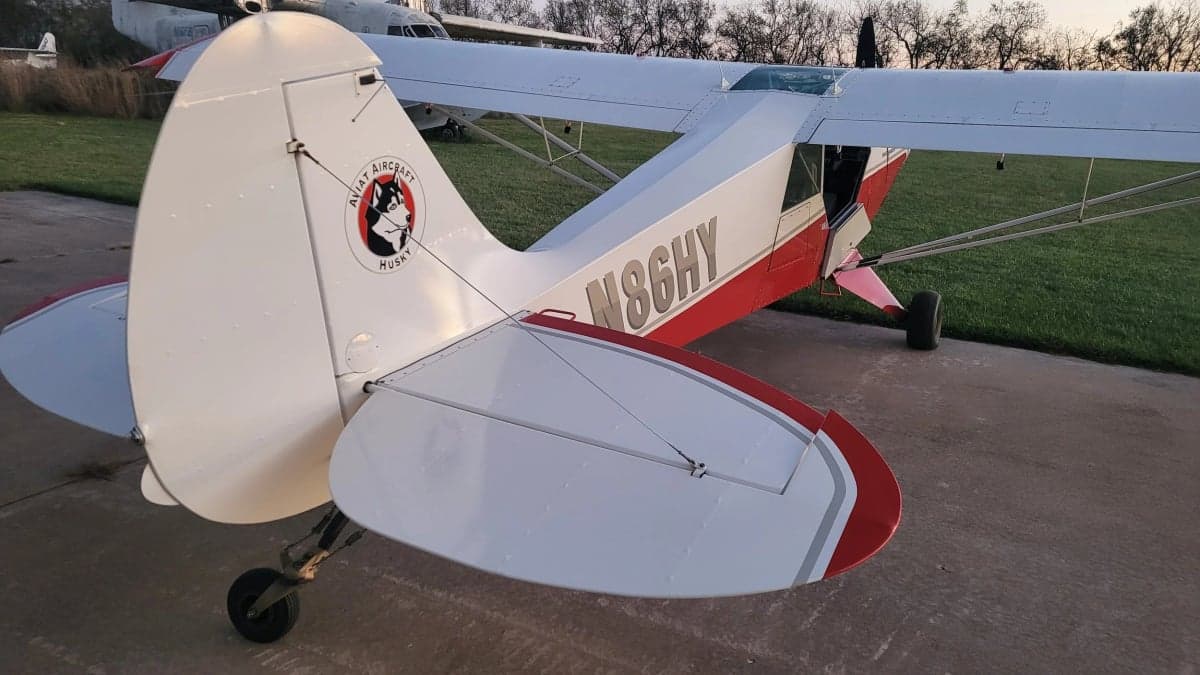 Rear view of the Aviat Aircraft Husky A-1B aircraft showing the tail and registration N86HY.