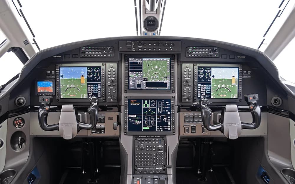 The modern glass cockpit of a Pilatus PC-12 aircraft, featuring multiple large digital displays.