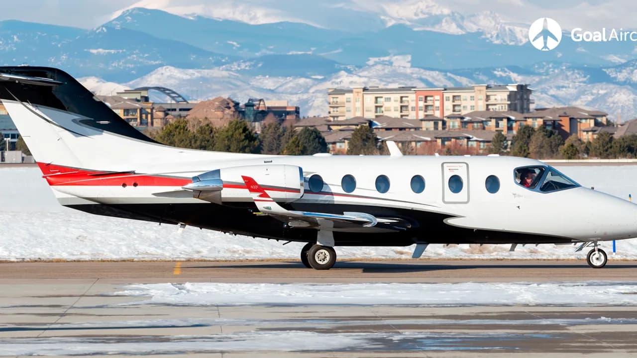 A Hawker 400XP on the tarmac with mountains in the background.