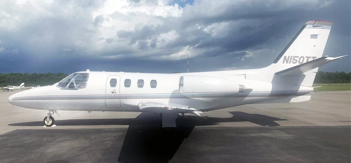 Side view of the white Cessna CitationJet N150TT on the tarmac.
