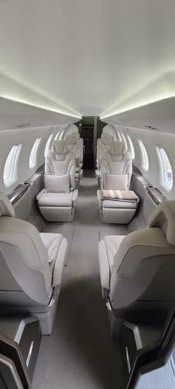 A view down the aisle of the aircraft cabin with seating.