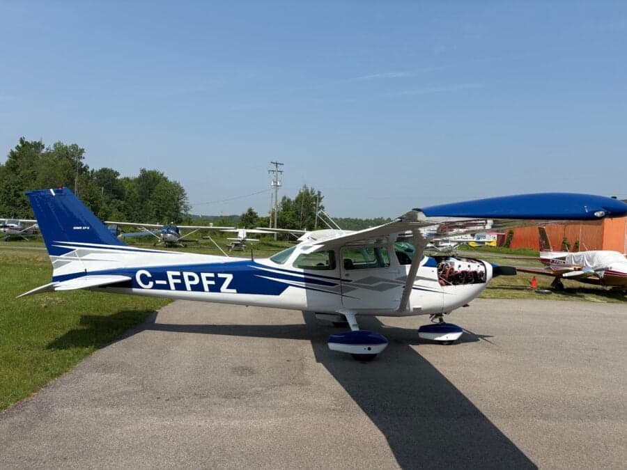 Cessna 210 HP aircraft C-FPFZ parked on the tarmac.
