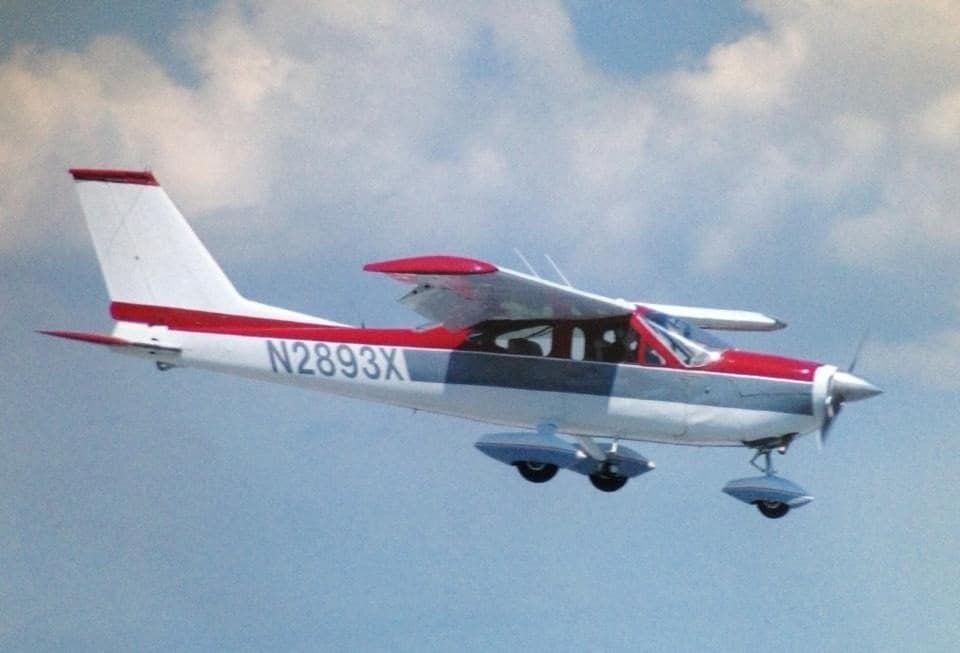 Cessna 177 Cardinal with a red and gray paint scheme in flight.
