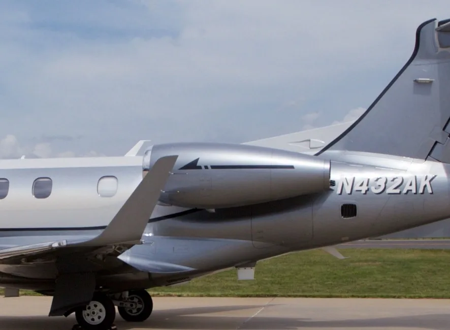 A close-up view of the tail and engine of the Embraer Phenom 300E business jet, N432AK.
