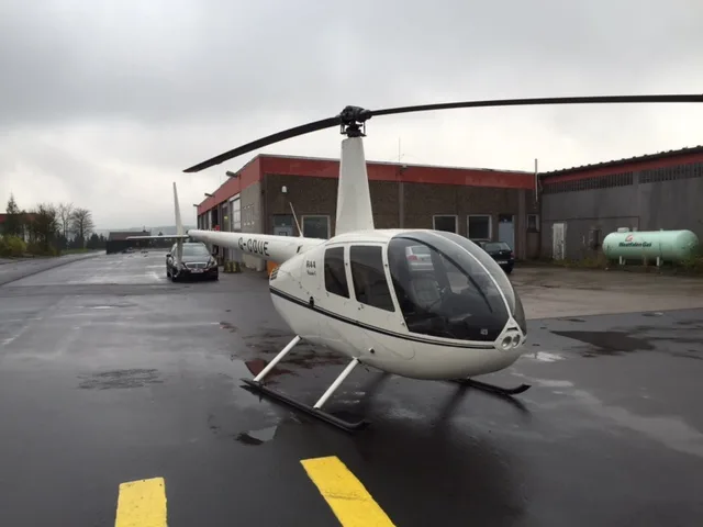 Robinson R44 Raven on the tarmac with a white paint scheme.