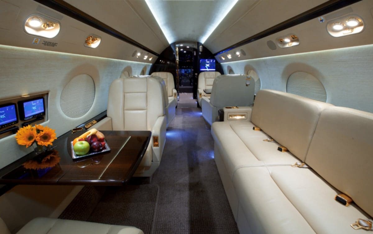 View of the aircraft interior with leather seats and a table.