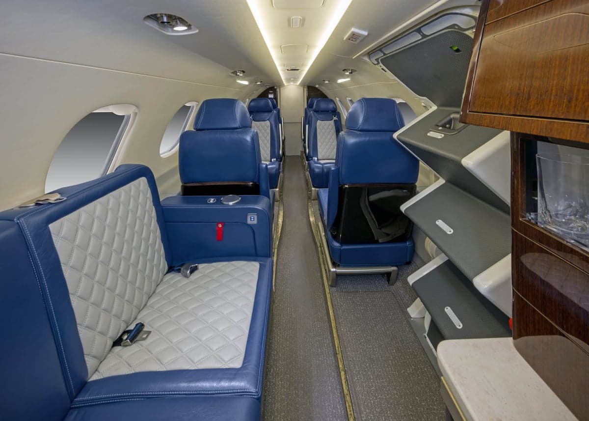 The interior of the aircraft, featuring blue and white seats.