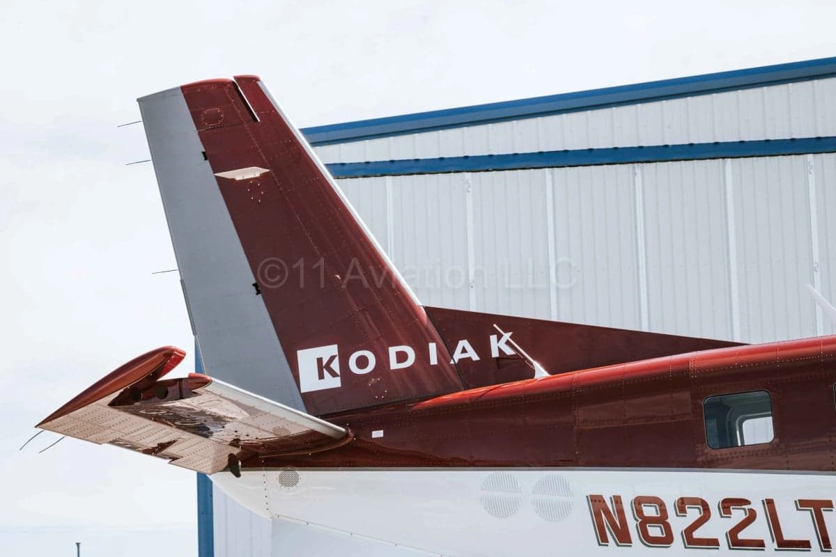 A close-up view of the tail section of a red and white Kodiak aircraft, showing the registration N822LT.