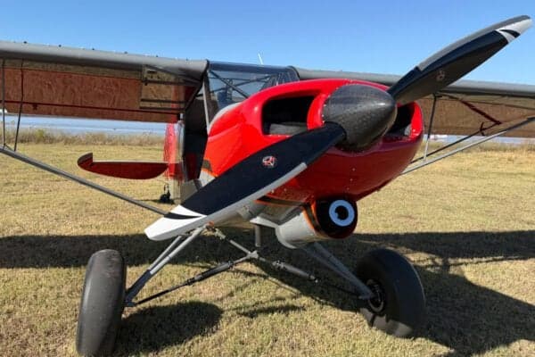 Front view of the red and gray Legend Cub aircraft on the ground.