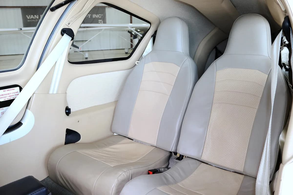 The light beige and grey leather seats in the cabin of the aircraft.