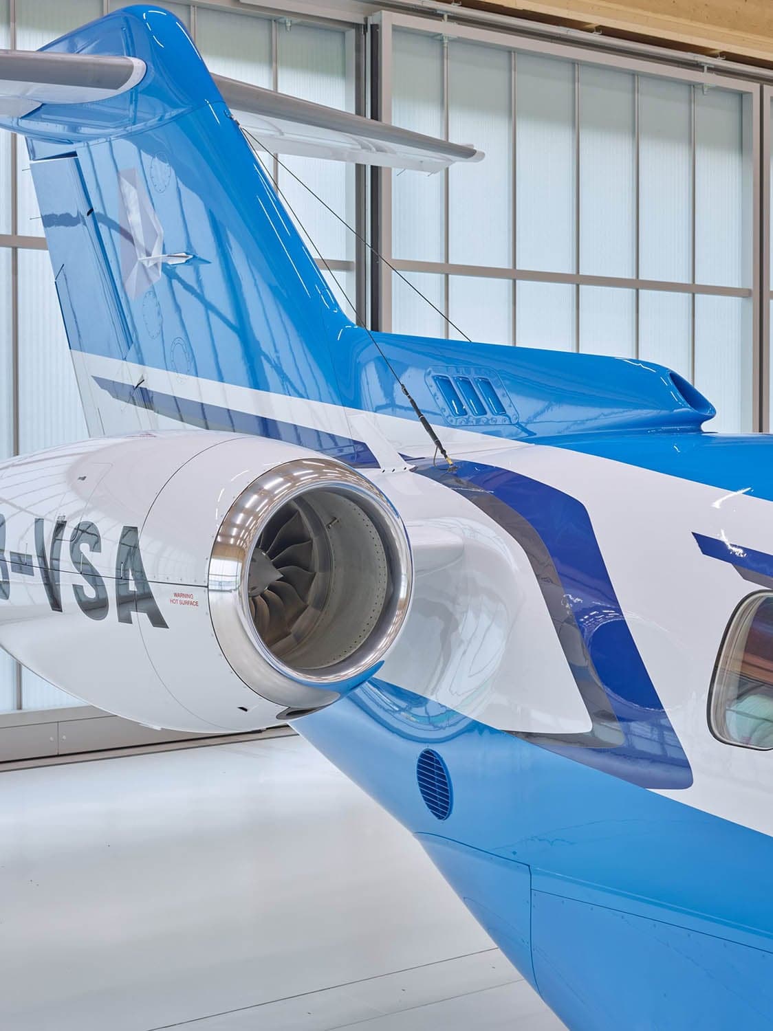 Close up of the tail and engine of a Pilatus PC-24 with blue and white paint scheme.