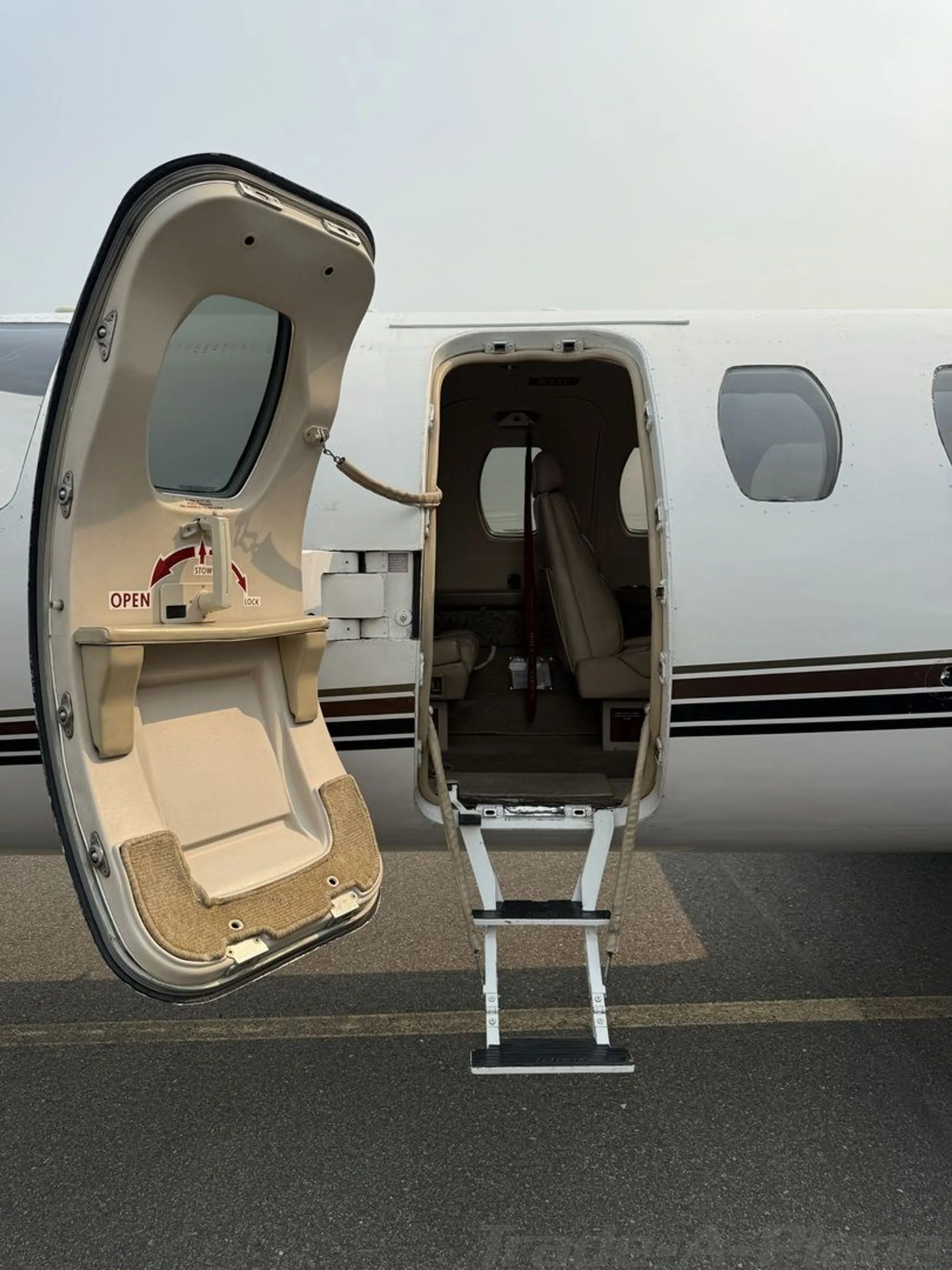 The main entry door of the Cessna Citation jet, N90JJ, open with integrated stairs extended.