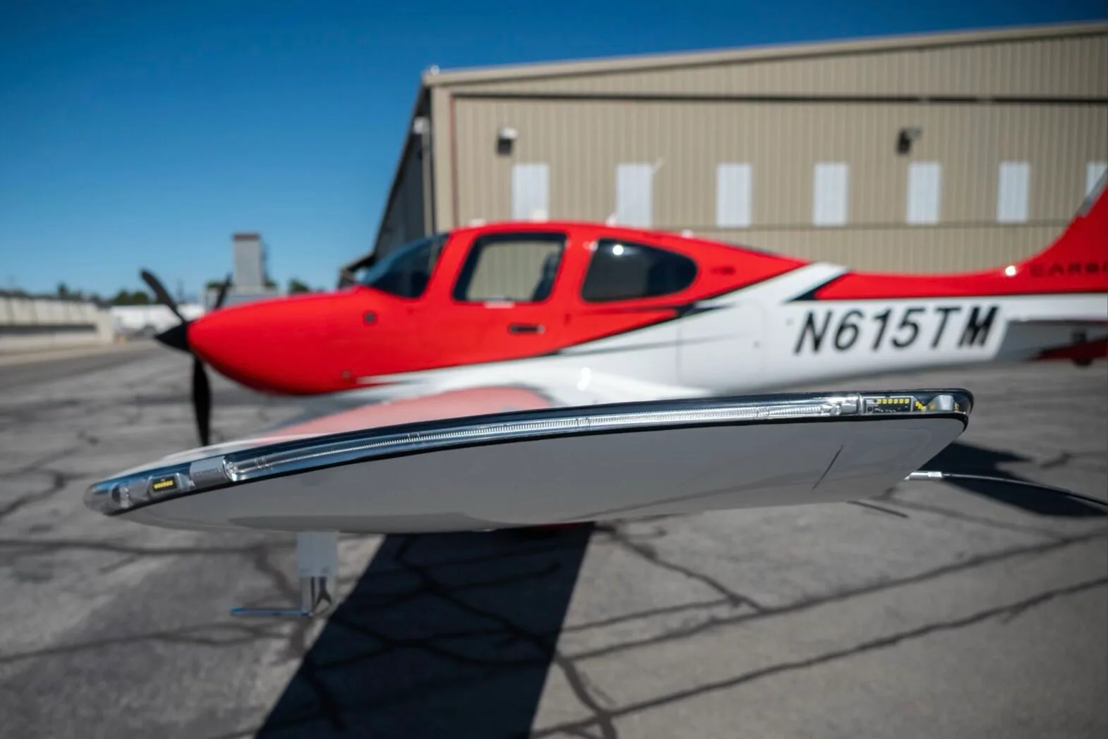 Close-up view of the wingtip of the red and white N615TM aircraft, showing navigation lights.