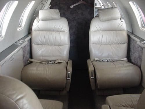 Two leather seats inside the aircraft cabin.