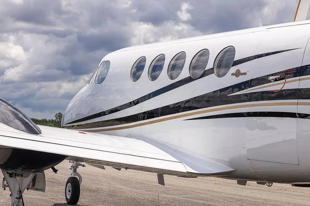 Close-up of the side of a King Air aircraft with registration N216RP showing the windows and paint scheme.