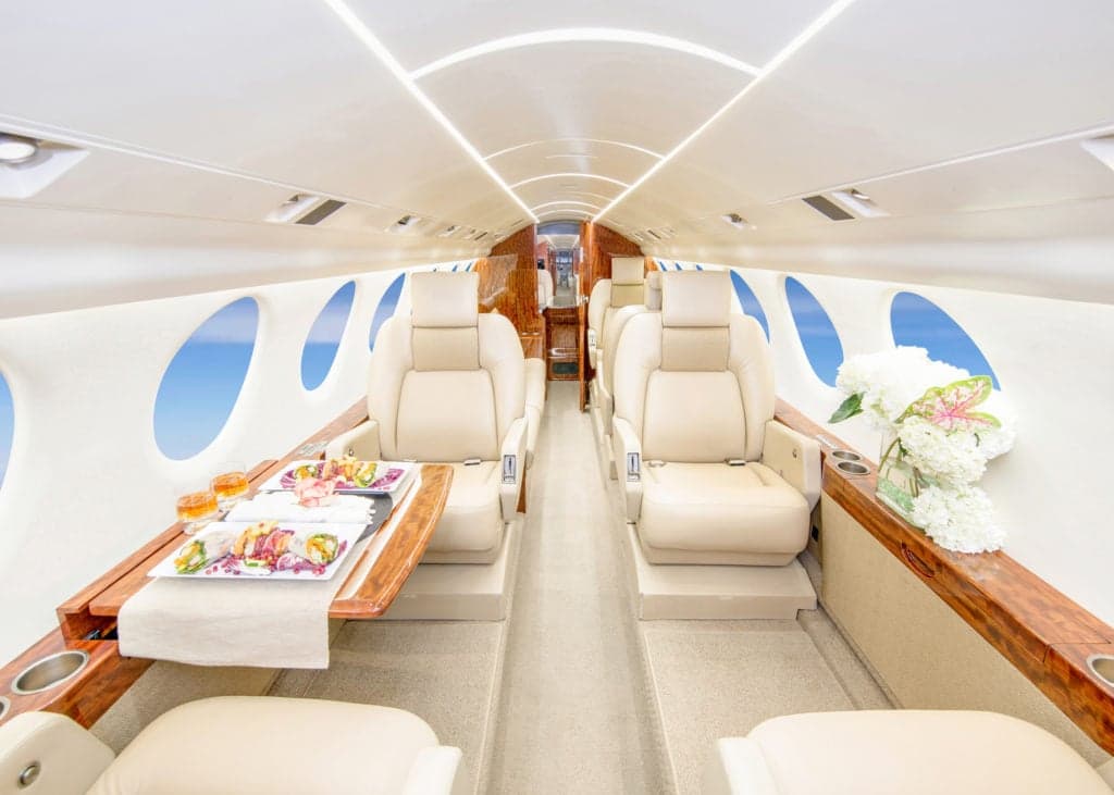 View of the interior cabin with cream-colored leather seats and a couch.