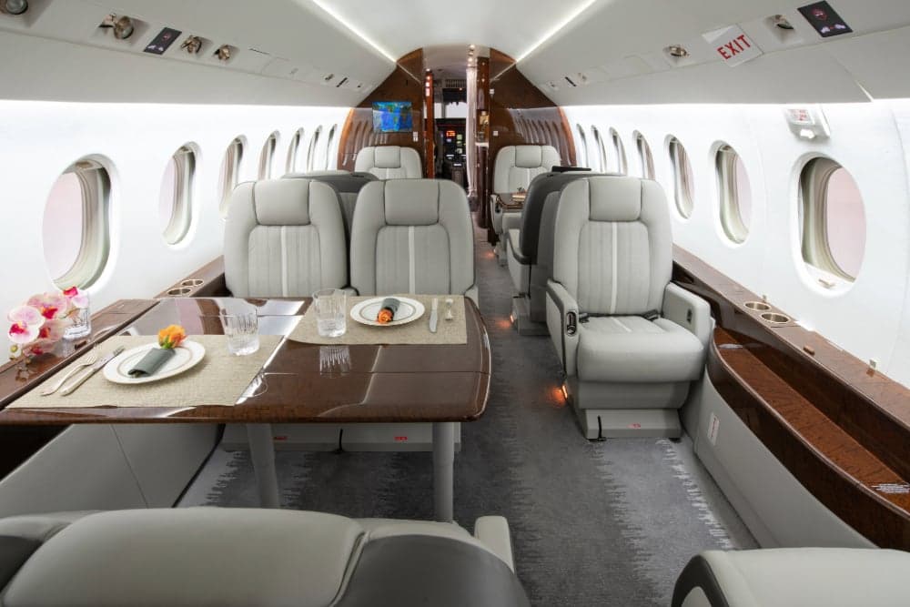 View of the aircraft interior with dining table set for a meal.