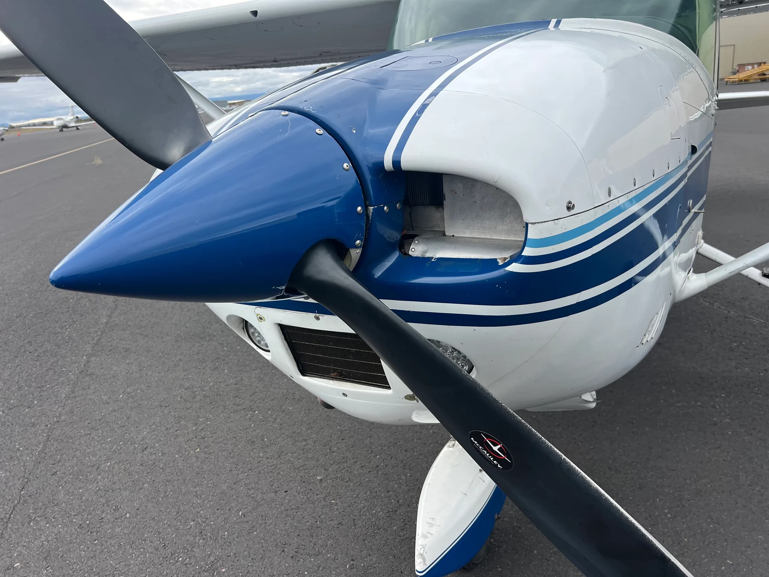 A close-up view of the blue and white propeller and cowling of the Cessna 172 aircraft, N58923.