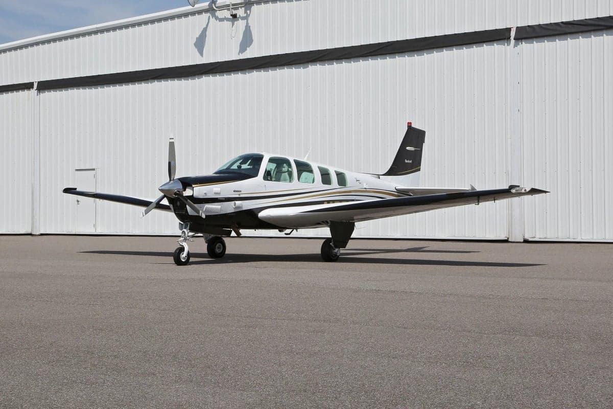 Side view of a Beechcraft Bonanza aircraft on the tarmac.