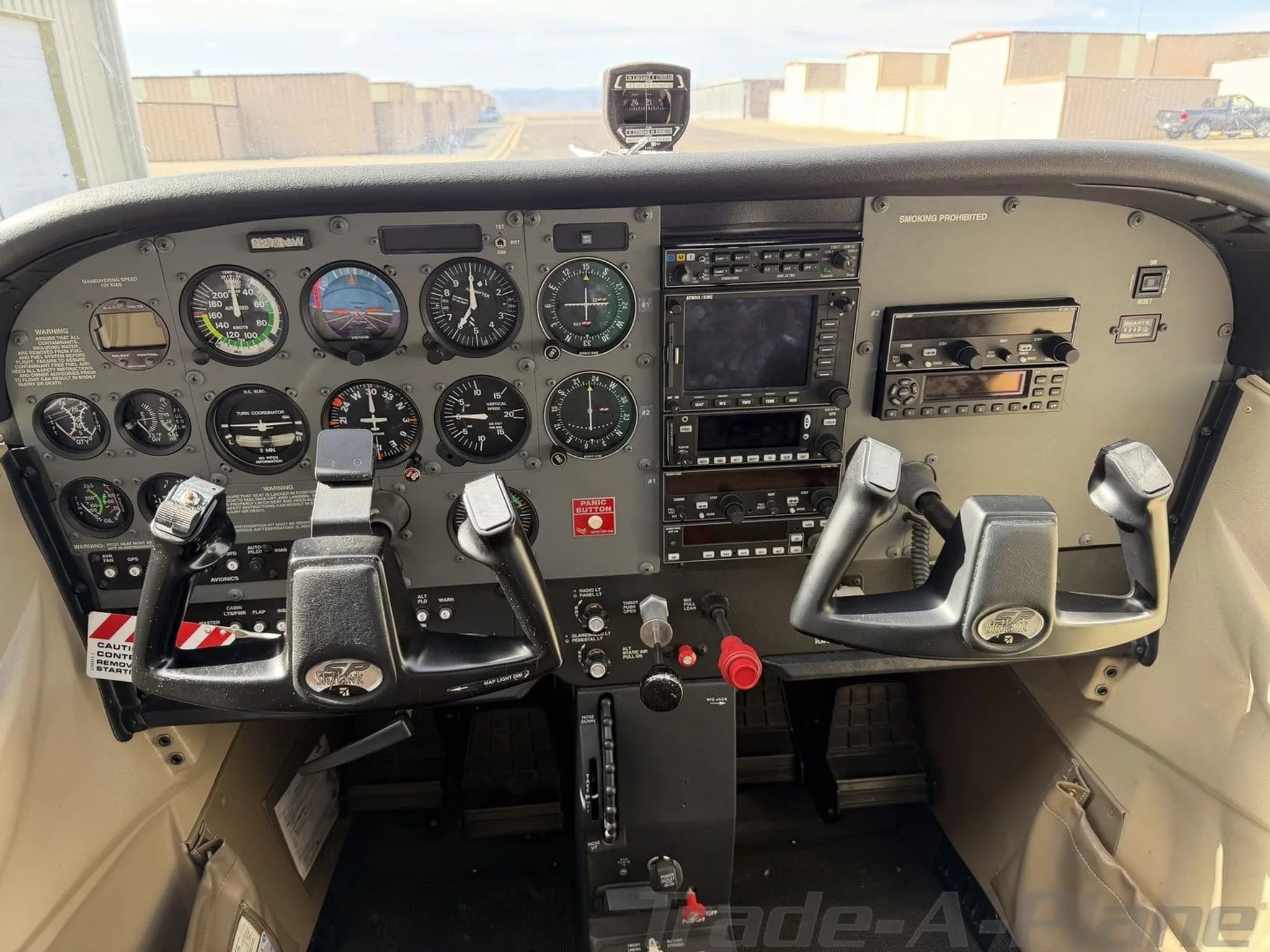 The cockpit of a Cessna 172 Skyhawk, showing the instrument panel with analog gauges and a modern GPS display.