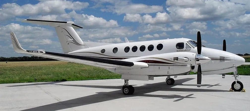 A King Air B200 turboprop aircraft is parked on the ramp.