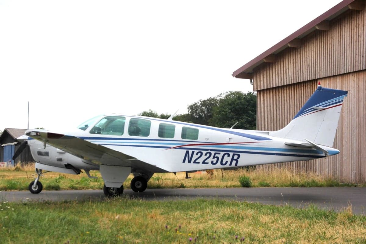 Side view of N225CR Beechcraft Bonanza with registration number visible.
