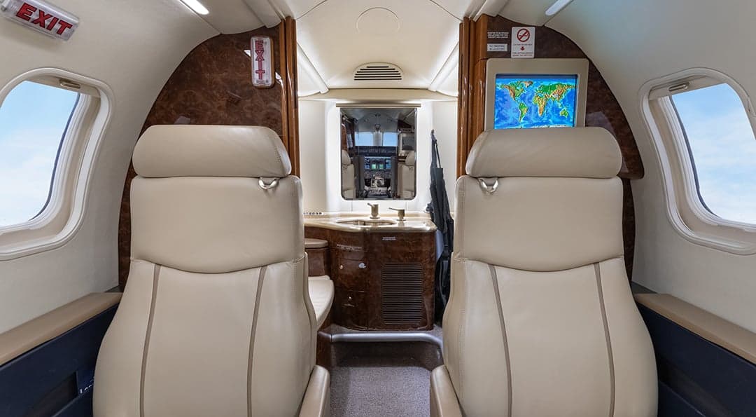 View of the Learjet 45XR cabin with leather seats and a sink.