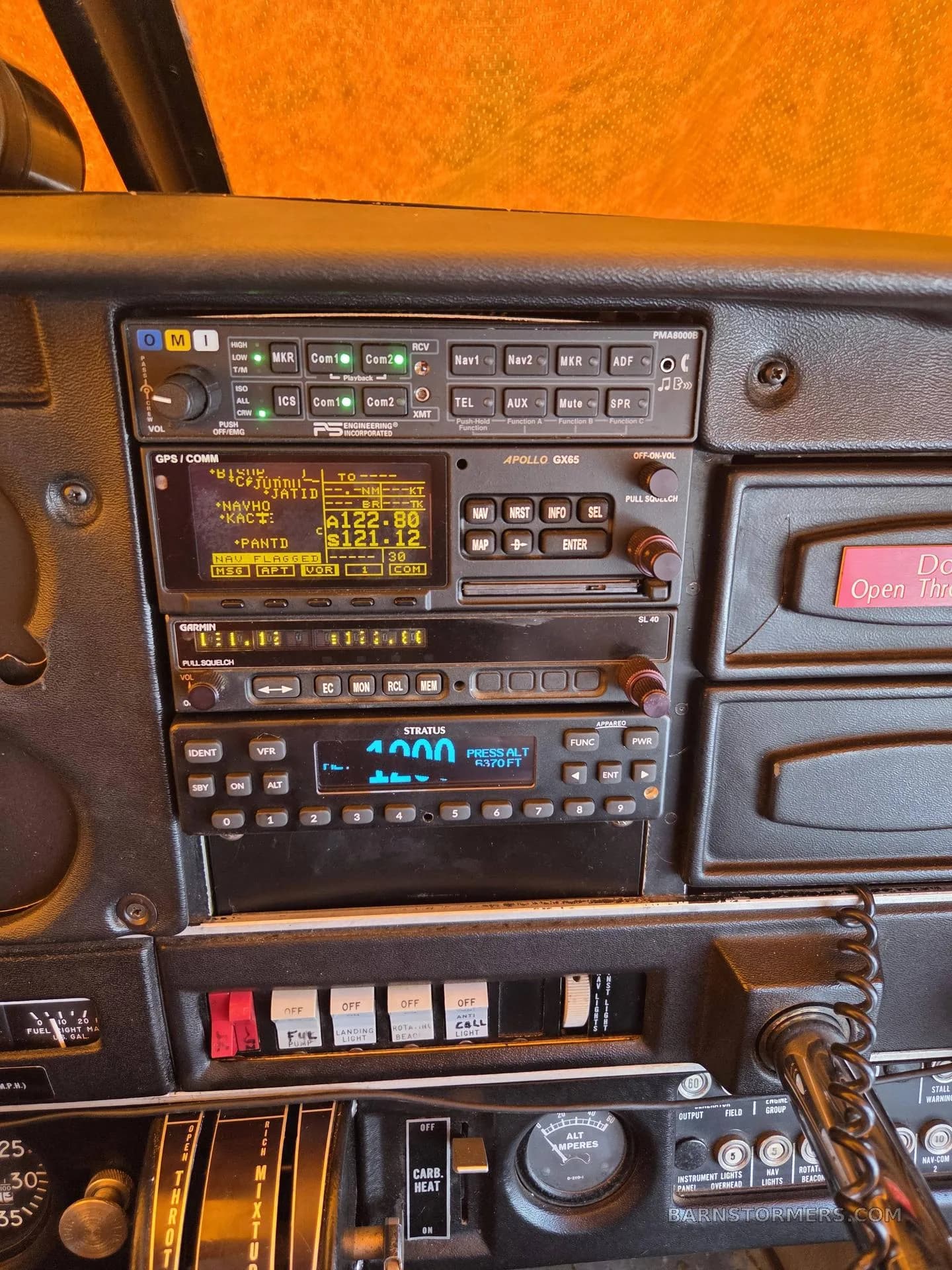 A close-up view of the avionics stack in an aircraft cockpit, showing various radios and navigation units.