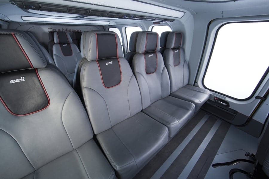 The interior of a Bell helicopter with gray leather seats.